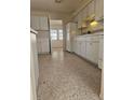 Traditional style kitchen with white cabinets, speckled floor, and basic appliances at 1778 23Rd St, Sarasota, FL 34234