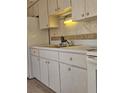 Close-up of traditional style kitchen with white cabinets and tile backsplash at 1778 23Rd St, Sarasota, FL 34234