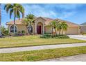 Charming single-story home with lush landscaping, a vibrant red front door, and a spacious two-car driveway at 2281 Vintage St, Sarasota, FL 34240