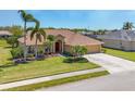 Charming single-story home with lush landscaping, a vibrant red front door, and a spacious two-car driveway at 2281 Vintage St, Sarasota, FL 34240