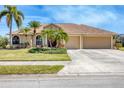 Charming single-story home with lush landscaping, a vibrant red front door, and a spacious two-car driveway at 2281 Vintage St, Sarasota, FL 34240