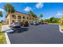 Condo building with palm trees and ample parking at 235 Rotonda W Blvd # C102, Rotonda West, FL 33947