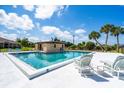 Outdoor pool with lounge chairs and small building at 235 Rotonda W Blvd # C102, Rotonda West, FL 33947
