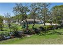 Expansive front yard view showcasing lush greenery, mature trees, and a charming playset at 3903 71St E St, Palmetto, FL 34221