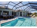 An inviting covered pool and spa area with an outdoor kitchen perfect for entertaining guests at 42207 Lake Timber Dr, Punta Gorda, FL 33982