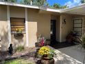 Inviting front entrance features vibrant flower pots and a covered walkway to the front door at 5013 Village Gardens Dr # 34, Sarasota, FL 34234