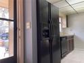 An interior view showcasing kitchen appliances, including a refrigerator and dishwasher, set against a tiled floor at 5013 Village Gardens Dr # 34, Sarasota, FL 34234