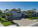 Beautiful single-story home with a paved driveway and tropical landscaping at 5621 Badini Way, Palmetto, FL 34221