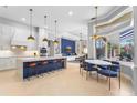 Open-concept kitchen and dining area with large island and modern pendant lighting at 6637 Taeda Dr, Sarasota, FL 34241