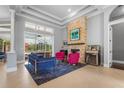 Bright living room with stone fireplace, stylish furniture, and sliding glass doors to the pool at 6637 Taeda Dr, Sarasota, FL 34241