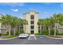 Exterior of condo building with palm trees, covered parking, and accessible parking spots at 7015 River Hammock Dr # 204, Bradenton, FL 34212