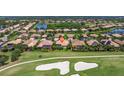 Scenic aerial shot of a residential area showcasing houses with pools and lush green landscape next to a golf course at 8004 River Preserve Dr, Bradenton, FL 34212