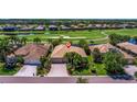 Aerial view of a well-maintained property with a large roof, situated on a lush green landscape with a golf course nearby at 8004 River Preserve Dr, Bradenton, FL 34212