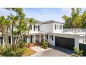 Beautiful two-story home with palm trees, white columns, black shutters and an attached garage at 813 Hudson Ave, Sarasota, FL 34236