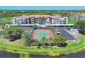 Aerial view showcasing the community tennis court, parking, and surrounding landscaping at 9620 Club South Cir # 5306, Sarasota, FL 34238