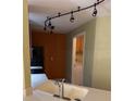 A cozy kitchen with light countertops, track lighting, and a view into the laundry room at 5691 Bentgrass Dr # 15-102, Sarasota, FL 34235