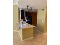 An open kitchen with dark cabinets, stainless hood, light countertops and track lighting at 5691 Bentgrass Dr # 15-102, Sarasota, FL 34235