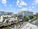 Expansive city view featuring buildings and palm trees under a bright blue sky with puffy white clouds at 101 S Gulfstream Ave. # 9C, Sarasota, FL 34236