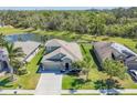 Aerial view of a well-maintained residential property with a manicured lawn and a serene pond in the backyard at 11037 77Th E St, Parrish, FL 34219