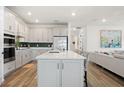 Modern kitchen with white cabinets, stainless steel appliances, and a large center island at 11221 Gallatin Trl, Parrish, FL 34219