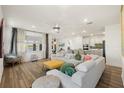 Bright, open-concept living room featuring hardwood floors, modern furnishings, and a lake view at 11221 Gallatin Trl, Parrish, FL 34219