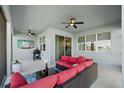 Relaxing covered patio with comfortable seating, ceiling fans, and a built-in grill at 11221 Gallatin Trl, Parrish, FL 34219