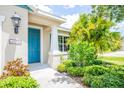Inviting front entrance with a bright blue door and well-manicured landscaping, enhancing curb appeal at 11790 Fennemore Way, Parrish, FL 34219