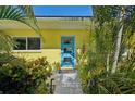 Bright and inviting front door with a modern design surrounded by lush tropical landscaping at 1248 Jefferson Dr, Englewood, FL 34224
