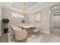 Elegant dining room with modern chandelier, neutral decor and tile flooring at 12659 Sorrento Way, Bradenton, FL 34211