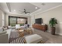 Bright living room features tray ceiling, fan, sleek furniture, and backyard access at 12659 Sorrento Way, Bradenton, FL 34211