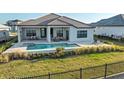 Inviting backyard with pool, spa, covered patio, and lush greenery perfect for outdoor relaxation and entertaining at 1702 4Th St E E St, Palmetto, FL 34221