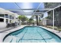 Sparkling screened-in pool offers a refreshing escape, complemented by a shaded patio and lush greenery in the backyard at 2213 Wason Rd, Sarasota, FL 34231