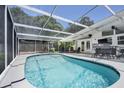 Relaxing screened-in pool features ample seating and an adjacent backyard, ideal for leisure and entertaining guests at 2213 Wason Rd, Sarasota, FL 34231