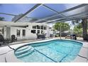 Inviting screened-in pool area with clear blue water and shaded seating, perfect for relaxation and outdoor entertainment at 2213 Wason Rd, Sarasota, FL 34231