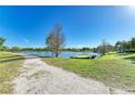 Backyard view of the tranquil lake with a boat on the shore at 2233 Beneva Ter # 2232, Sarasota, FL 34232