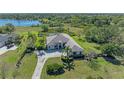 Aerial view of a beautifully landscaped property overlooking a serene lake surrounded by lush greenery at 22354 Panther Loop, Bradenton, FL 34202