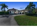 Charming home features a stone facade, three-car garage, and palm trees in a well manicured yard at 22354 Panther Loop, Bradenton, FL 34202