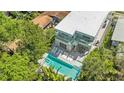Aerial view of the modern home highlighting the pool, balconies, and surrounding lush greenery at 2327 Hillview St, Sarasota, FL 34239