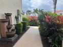 Inviting garden walkway with lush foliage, flowers, and an eye-catching waterfall feature at 2334 Felicity Pl, North Port, FL 34289