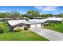 Well-manicured lawns surround paired single-story homes with attached garages and clean rooflines at 3140 Village Green Dr # 1119, Sarasota, FL 34239
