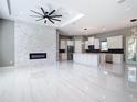 Spacious living room with a modern fireplace, sleek ceiling fan, and luxurious marble flooring at 3367 Tucson Rd, North Port, FL 34286