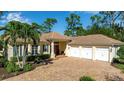 Beautiful home featuring a brick driveway and an attached three-car garage at 402 Walls Way, Osprey, FL 34229