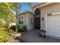 Close-up of the front door with decorative glass and well-maintained landscaping at 4134 63Rd E Ter, Sarasota, FL 34243