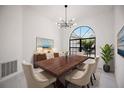 Elegant dining room with a dark wood table, chandelier and view of the backyard at 4444 Robin Hood Trl W, Sarasota, FL 34232