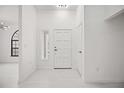 Bright entryway with neutral colors and a modern front door, complemented by sleek flooring at 4444 Robin Hood Trl W, Sarasota, FL 34232