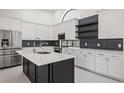 Updated kitchen with stainless appliances, spacious island, and decorative backsplash at 4444 Robin Hood Trl W, Sarasota, FL 34232
