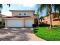 Beautiful two-story home with a tile roof, a two-car garage, and lush landscaping at 4510 Murcia Blvd # 16, Sarasota, FL 34238