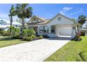 Charming home featuring arched windows, well-maintained landscaping, and a brick driveway at 4624 Blue Marlin Dr, Bradenton, FL 34208
