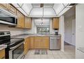 Well-lit kitchen with stainless steel appliances, tile floors, and a breakfast bar overlooking the dining area at 5201 Lake Village Dr # 14, Sarasota, FL 34235