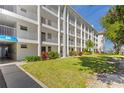 Clean, well-maintained building with a lush green lawn and colorful landscaping at 600 Sutton Pl # 104, Longboat Key, FL 34228